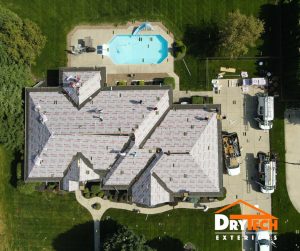 top view of a house with white roof and a pool