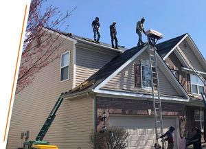 picture of three individuals on the roof with one person below holding a ladder